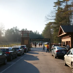 Parking area and entrance at Hitchcock Woods during the Aiken Horse Show with parked cars, volunteers, and horses in the distance.