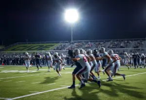 High school football players in action during a night game