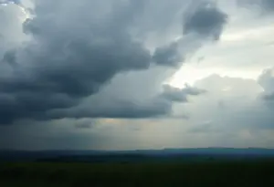 Symbolic representation of domestic violence awareness with dark clouds over a serene landscape.