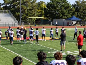 Hephzibah High School football field with students and coaches.