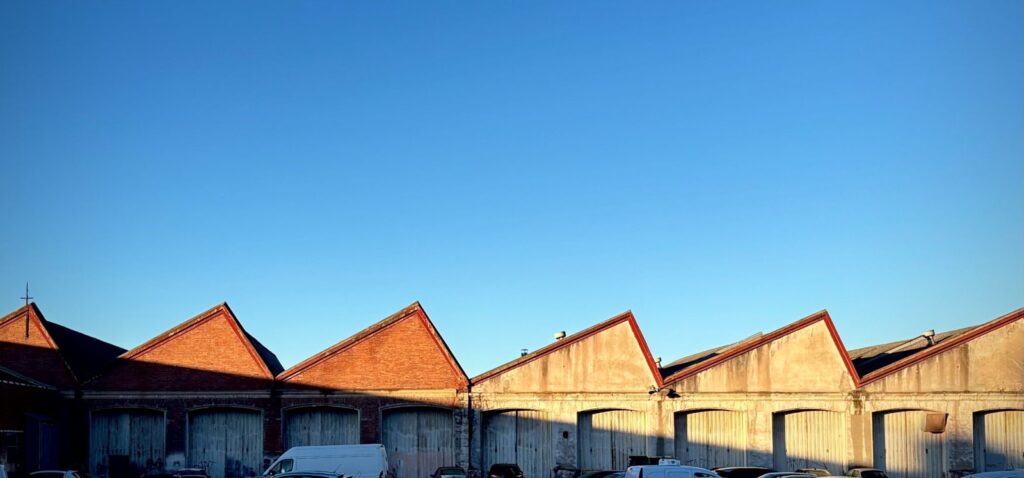 Row of industrial warehouse buildings with red roofs